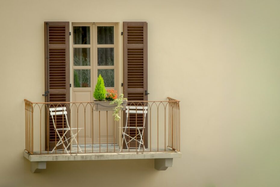 Balcony with chairs and a small tree.